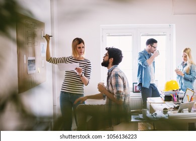 Group Of Focused Innovative Young Designers Sharing Ideas In The Office.