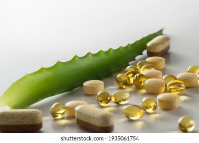 A group of food additives diffrent shape and colors with green leaf of aloe vera on  white background. As a concept of natural medicines. Preventive medicine. Place for text