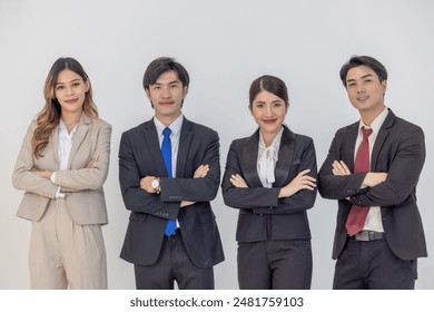 A group of four asian professionals in formal business attire standing against a plain background, representing confidence, teamwork and corporate collaboration. - Powered by Shutterstock