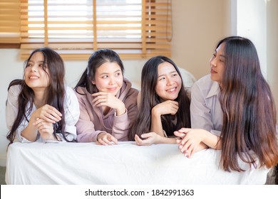 Group Of Four Asian Women Lying On Bed Smile Look At Camera Feels Happy  Friends Or Teenage Girls Having Fun In Cozy Room At Home