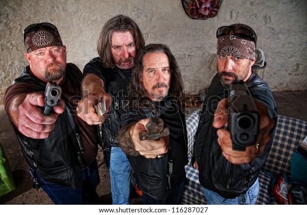 Group of four bikers in leather jackets\
brandishing weapons