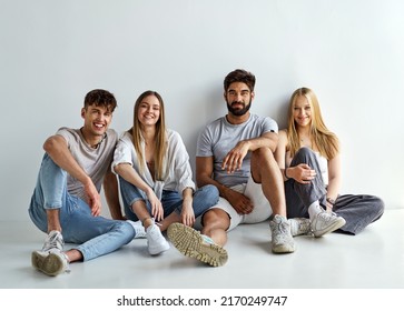 Group Of Four Friends Sitting And Looking At The Camera