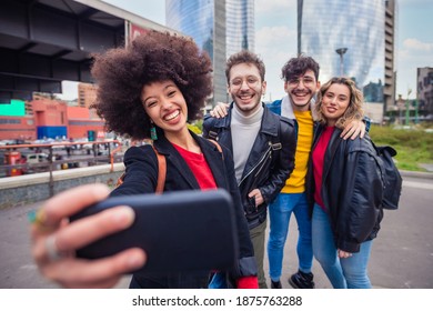 Group of four people diverse multiethnic tourist having fun taking selfie in front in Milan sharing on social network making memories and enjoying good times together - Shutterstock ID 1875763288