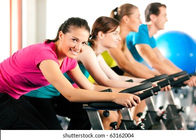 Group of four people in the gym, exercising their legs doing cardio training - Powered by Shutterstock