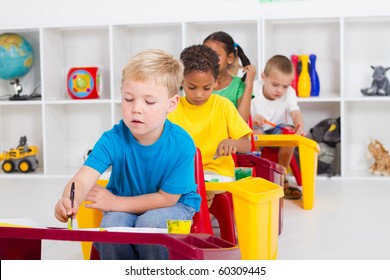 Group Of Four Preschool Kids In Classroom Painting Picture