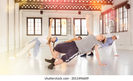 Group Of Four Teenage Dancers Having Break Dance Training At Dance Studio