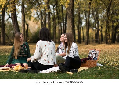 Group Of Four Women On A Fun Fall Picnic In The Park, Having A Good Time.