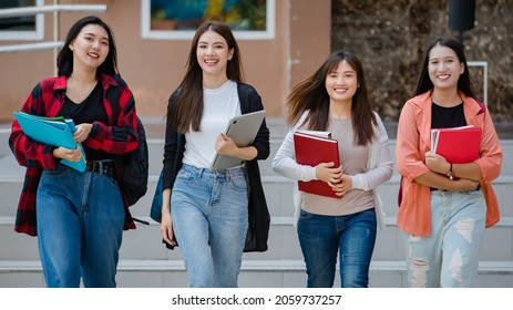 Group Of Four Young Attractive Asian Girls College Students Walking Together In University Campus Talking And Laughing With Joy. Concept For Education And College Students Life.