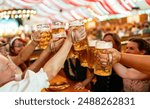 group of freinds in traditional Bavarian attire raising beer steins in a toast at a festive indoor event in an Oktoberfest or dult tent with red and white drapes in the background