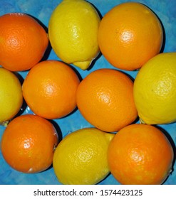 Group of fresh oranges and lemons against a blue turquoise ceramic background. Studio shot. United Kingdom, November 29, 2019