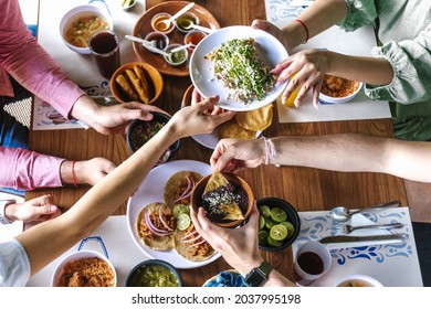 group of Friend eating Mexican Tacos and traditional food, snacks and peoples hands over table, top view. Mexican cuisine - Shutterstock ID 2037995198