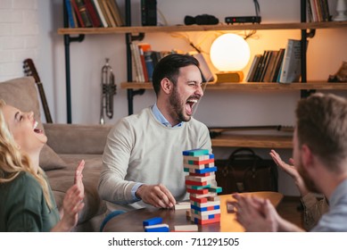 Group Of Friend Playing A Jenga At Home.