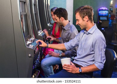 Group Of Friend Playing With Slot Machines