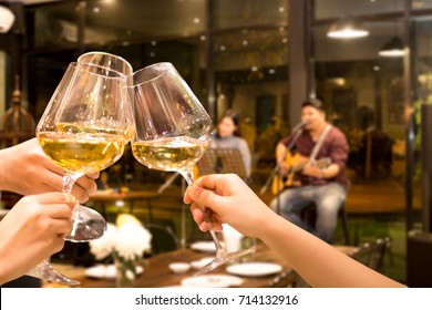 Group Of Friend Toasting With Wine For Celebration Live Band In Background