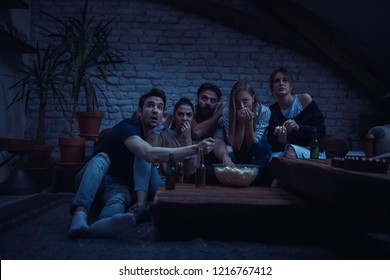 Group Of Friend Watching Scary Movie At Home