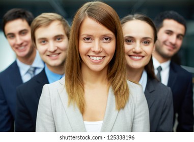 Group of friendly businesspeople with happy female leader in front - Shutterstock ID 125338196