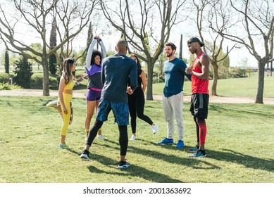 Group Of Friendly Runners Talking In A Park Before Training.