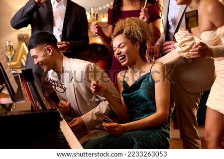 Group Of Friends Around Piano Celebrating At New Year Party Together Foto d'archivio © 