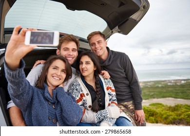 Group Of Friends At The Back Of Their Car Taking A Selfie While On A Roadtrip