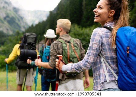 Group of friends with backpacks doing trekking excursion on mountain