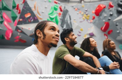 Group of friends being given safety briefing by male coach at indoor wall climbing centre - Powered by Shutterstock