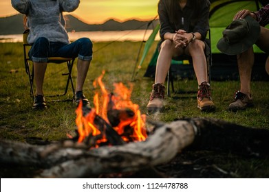 Group of friends camping.They are sitting around fire camp.