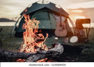 Group of friends camping.They are sitting around fire camp. - Shutterstock ID 1135004924