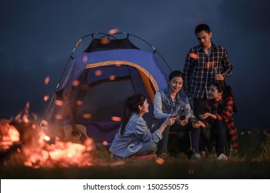 Group of friends camping.They are sitting around fire camp. - Powered by Shutterstock