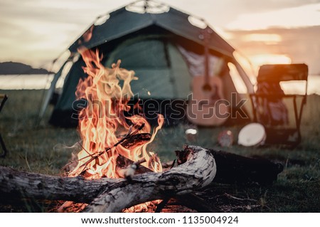 Group of friends camping.They are sitting around fire camp.