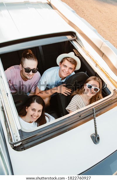 group of\
friends in car looking up through\
sunroof