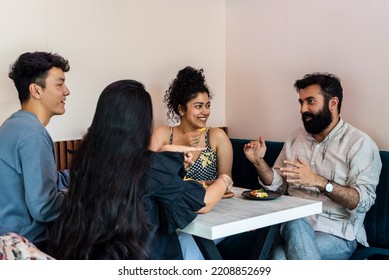 A group of friends catch up over a meal at a cafe.
