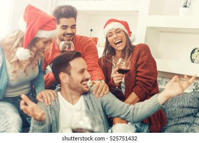 Group Of Friends Celebrating Christmas At Home, They Are Having Fun.