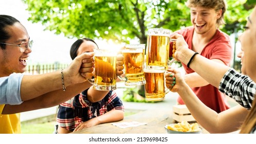 Group Of Friends Cheering Beer Glasses In Brewery Pub Garden - Young People Having Fun In Backyard Home Party - Dining Lifestyle And Youth Culture Concept