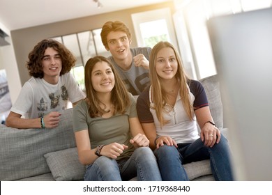 Group Of Friends Cheering Up As Watching Game On TV