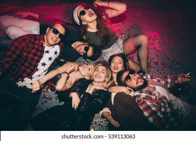 Group Of Friends At Club Lying On The Floor And Having Fun. New Year's Party
