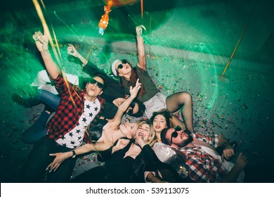 Group of friends at club lying on the floor and having fun. New year's party
