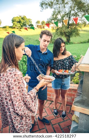 Gruppe von Freunden, die bei einem Sommergrill kochen.