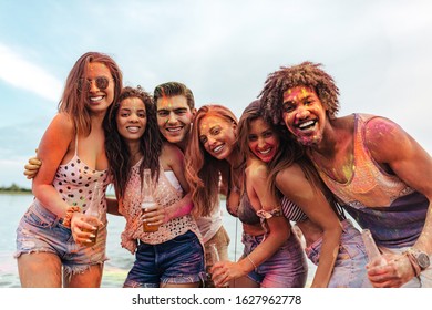 Group of friends covered in paint outdoors - Shutterstock ID 1627962778