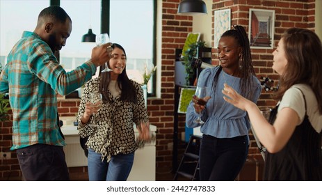 Group of friends dancing at apartment party, having fun together, moving their feet on rhythm. BIPOC people doing energetic dance moves on upbeat songs in brick wall living room