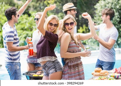 Group Of Friends Dancing At Outdoors Barbecue Party Near Pool