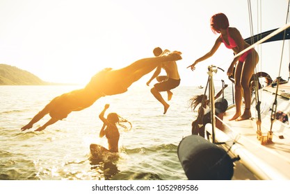 group of friends diving in the water during a boat excursion - Shutterstock ID 1052989586