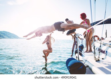 Group Of Friends Diving In The Water During A Boat Excursion