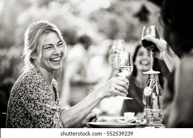 Group Of Friends Doing A Bbq, Focus On A Beautiful Woman Toasting With Her Glass Of Wine. A Beautiful Garden In The Background, Black And White