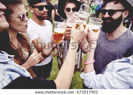 Group of friends drinking a beer at the festival 