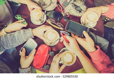 Group of friends drinking cappuccino at coffee bar restaurant - People hands using smartphone on upper point of view - Technology concept with addicted men and women - Desaturated lomo vintage filter