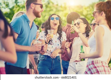 Group Of Friends Drinking, Chatting And Having A Good Time At Outdoor Party