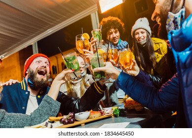 Group Of Friends Drinking At Cocktail Bar With Open Face Masks - Happy Young People Having Fun Together Toasting Drinks At Nightclub - New Normal Lifestyle Concept. Focus On Left Glass.