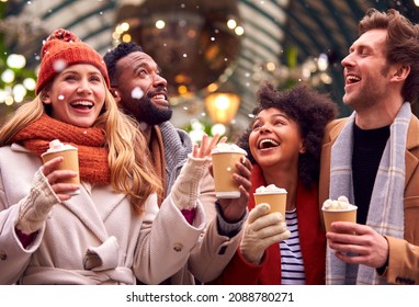 Group Of Friends Drinking Hot Chocolate With Marshmallows In Snow At Outdoor Christmas Market - Powered by Shutterstock