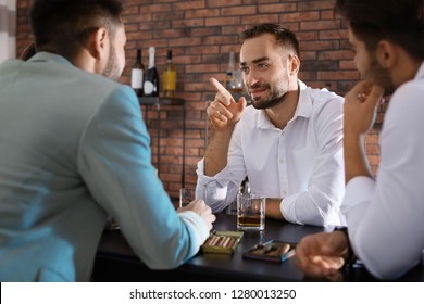 Group Of Friends Drinking Whiskey Together In Bar