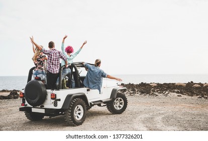Group of friends driving off road convertible car during roadtrip - Happy travel people having fun in vacation - Friendship, transportation and youth lifestyle holidays concept 